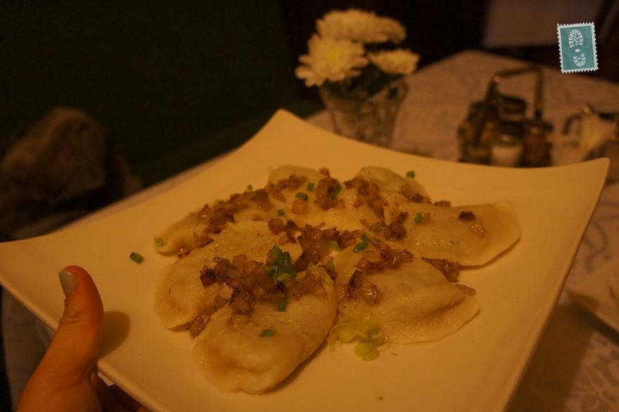 A plate of pierogi with fried onion